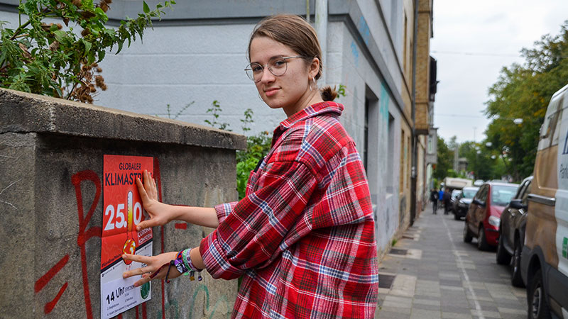 Vera Wagner hängt Plakate auf